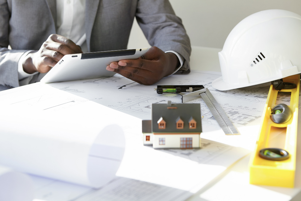 blueprints hard had and person holding tablet at table